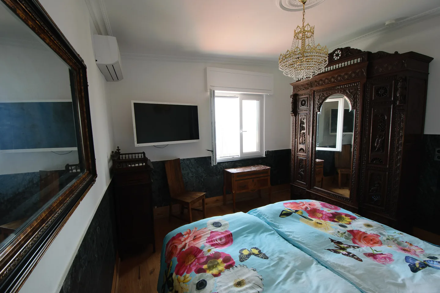 Schlafzimmer im Penthouse mit historischem Holzschrank und Naturstein